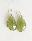 Green teardrop earrings on a light background
