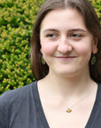 woman wearing necklace with brown pendant