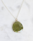 Necklace with a round green pendant on a white background