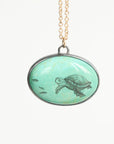 Necklace with a pendant featuring a turtle design on a light green background