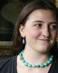 Woman wearing blue earrings and chunky strand
