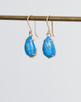 Pair of blue teardrop earrings on a white background