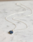 Necklace with a blue pendant on a marble surface