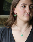 Woman wearing green pendant necklace