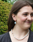 Woman wearing blue teardrop shaped earrings