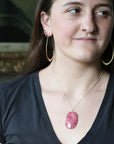 Woman wearing large pink stone pendant
