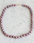 Pink pearl strand with lavender thread and gold barnacles