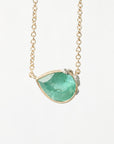 Necklace with a green teardrop pendant on a light gray background