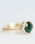 Side of gold Ruthie B. Ring with bright green stone. Clustered gold barnacles visible