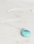 Turquoise pendant necklace on a marble surface