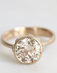 gold ring facing forward with a diamond and platinum barnacles against a white background