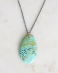 Necklace with a turquoise marbled pendant on a light background