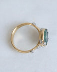 Large green sapphire ring with lots of barnacles. Gold shank