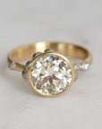 Gold ring with a large diamond on a light gray background