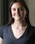 Woman wearing a dark gray shirt with a neutral background