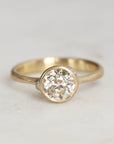 Gold ring with a diamond on a light gray background