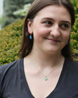 Woman wearing necklace with green pendant