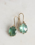 Green gemstone earrings on a light gray background
