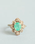 Green stone surrounded by golden rose setting