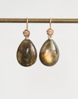 Teardrop-shaped earrings with gold accents on a white background