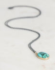 Necklace with a turquoise pendant on a light background