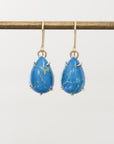 Pair of blue teardrop earrings on a white background