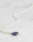 Necklace with a blue pendant on a light gray background