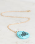 Necklace with a turquoise pendant featuring an octopus design on a light background