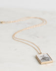 Necklace with a square pendant on a light background