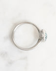 Silver ring with a small gemstone on a light gray background