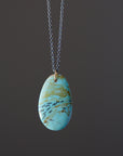 Necklace with a turquoise pendant on a dark background