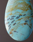 Marbled stone with turquoise and gold colors on a brown background
