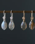 flashing with blue, grey labradorite cones hang beneath gold and silver ear wires and roses.