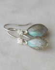 flashing with blue, grey labradorite cones hang beneath silver ear wires and roses.