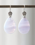 swirly pale blue lace agate teardrops hang beneath silver ear wires featuring little silver roses on them