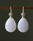 swirly pale blue lace agate teardrops hang beneath silver ear wires featuring little silver roses on them
