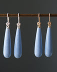 long teardrops of blue common opal hang beneath silver and gold ear wires and roses