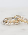 Three silver rings with barnacle designs on a light gray background
