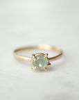 round cream montana sapphire set in a ring of prongs in a gold ring
