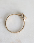 Gold ring with barnacles on a light marble background