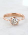 rose gold ring with diamond and three small side barnacles with diamonds- front view.