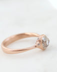 rose gold ring with diamond and three small side barnacles with diamonds- side view.