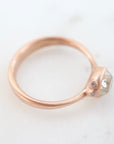 rose gold ring with diamond and three small side barnacles with diamonds- side view.