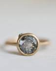 Gold ring with a large gemstone on a light gray background