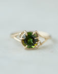 a lush green round tourmaline sits in gold branch prongs in this branch ring. front view.