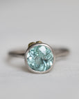 Silver ring with a light blue gemstone on a white background