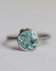Ring with a blue gemstone on a light gray background