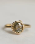 Gold ring with a gold sapphire on a light gray background