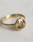 Gold ring with a gold sapphire on a light gray background