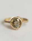 Gold ring with a gold sapphire on a light gray background